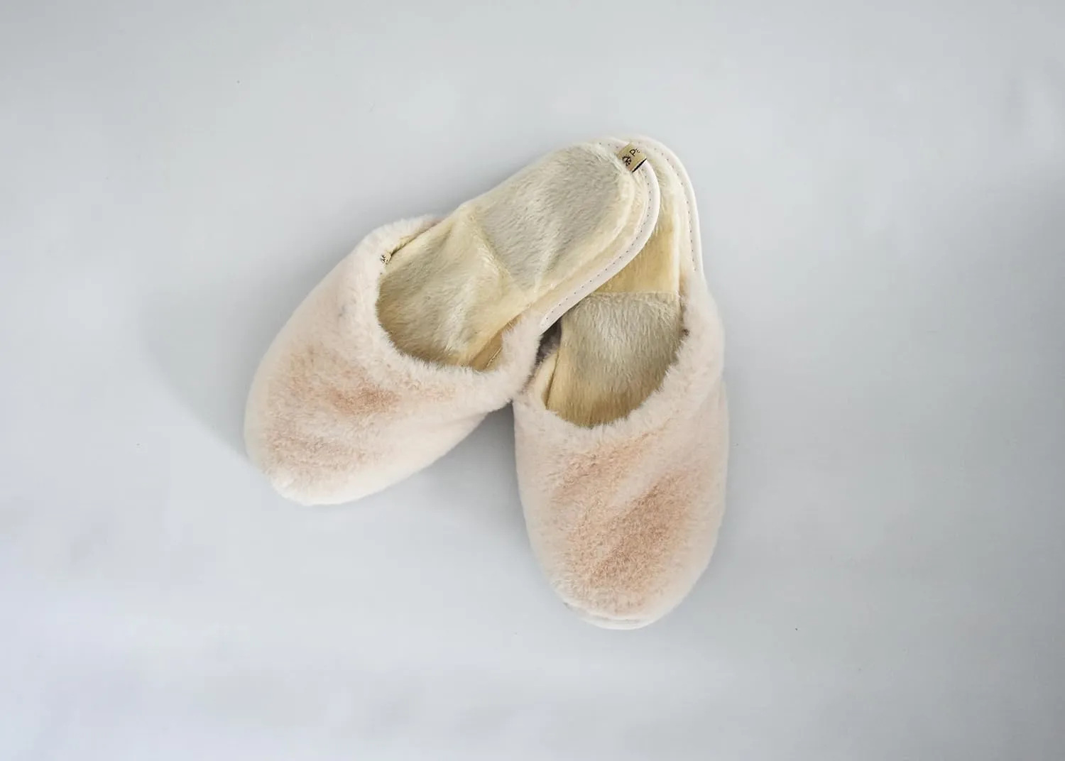 slide on Aromatherapy women's slippers featuring heatable lavender-filled aromatherapy insoles. Spa-style slide-on slippers with a fuzzy faux fur exterior.